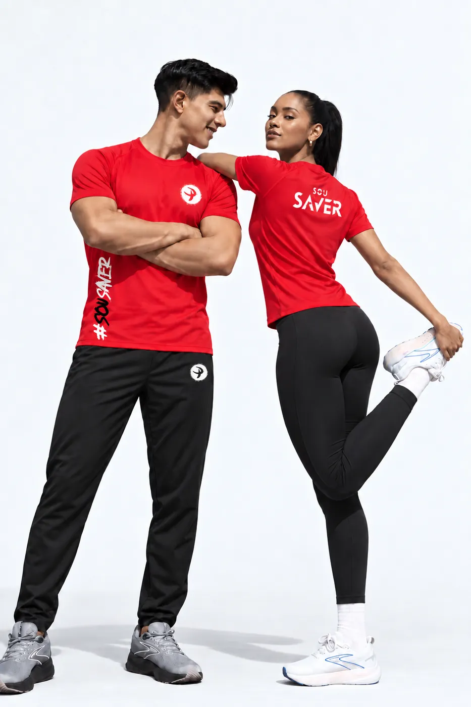 Dupla com camisetas vermelhas da Pratique, estampa Sou Saver nas costas e emblema branco na calça preta