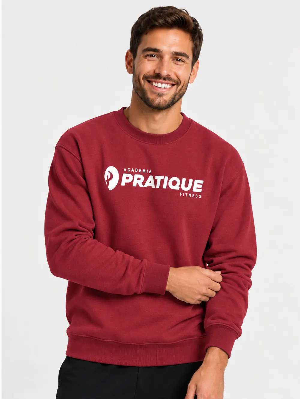 Homem sorridente com moletom bordô personalizado com a logo branca da Academia Pratique Fitness